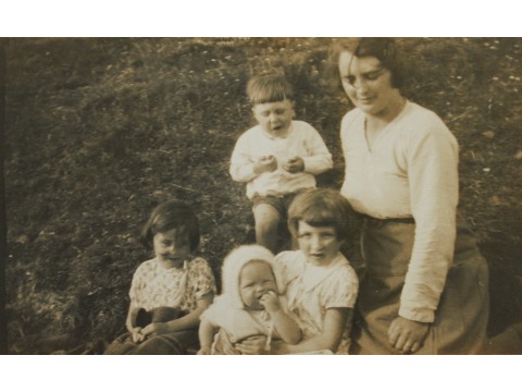Mrs Joyce Kinley's mother Esther is on the right with sister Winifred sitting front left (in floral dress). Mrs Joyce Kinley as a baby, wearing a bonnet, is sitting in the lap of a friend at the front. Cousin George East is sitting at the back centre. Date unknown