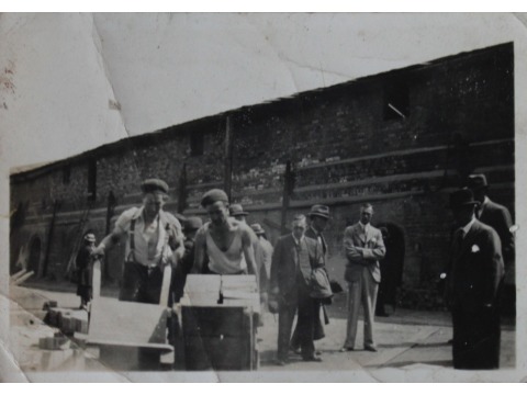 Mr Eric Kelly's father worked in the Peel Brickworks factory. Mr Eric Kelly believes his father is pictured 2nd from the left pushing a barrow. Date unknown.