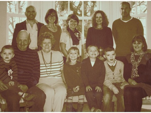 Family group canvas photograph taken in 2012. Mrs Audrey Crowe is sitting 3rd from the left next to her son Frank who is holding his son Fred. 